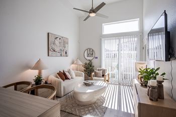 A living room with a white sofa, a white coffee table, and a white rug.